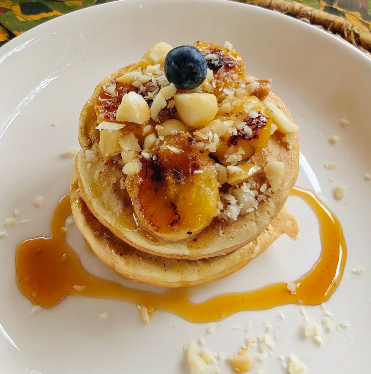 Banana and macadamia pancakes with honey and berries