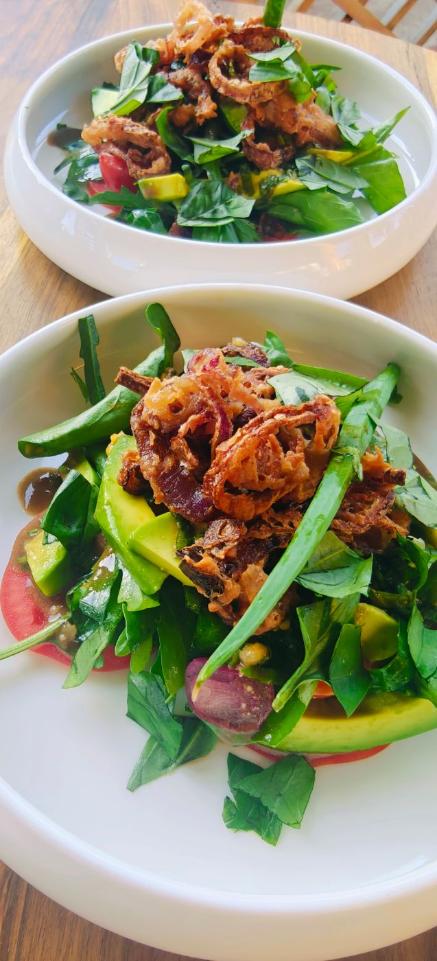 Two garden salads with crisp shallots and avocado